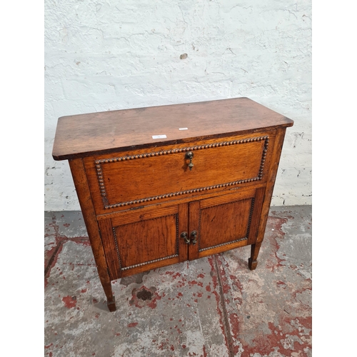 117 - A 1930s oak cabinet with fall front, two lower cupboard doors and beaded decoration - approx. 66cm h... 