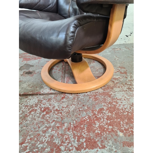 128 - A John Lewis brown leather and beech swivel reclining arm chair and foot stool - approx. 100cm high ... 