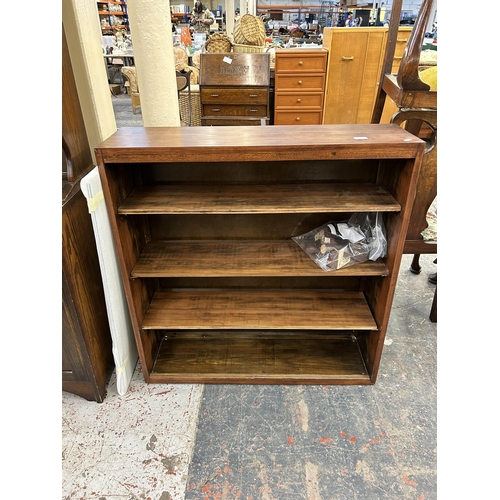 125 - A mid 20th century stained pine four tier bookcase with glass sliding doors and cabriole supports - ... 