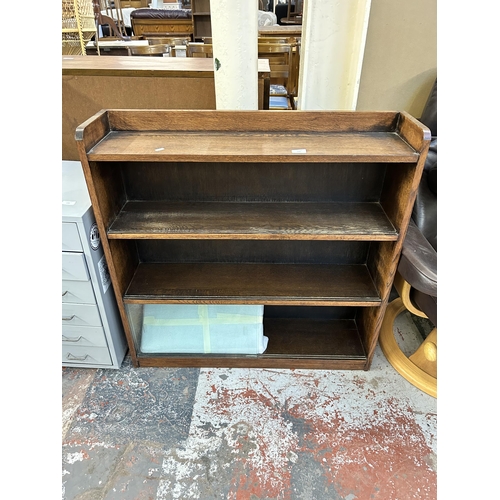 129 - A mid 20th century oak four tier bookcase with six glass sliding doors - approx. 92cm high x 91cm wi... 