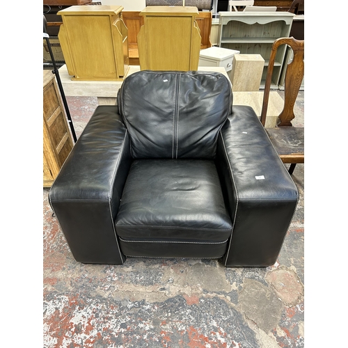 132 - A Soflex black leather armchair - approx. 90cm high x 111cm wide x 98cm deep