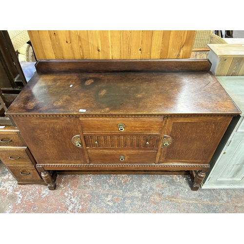 140 - An oak sideboard with three central drawers, two outer cupboard doors and baluster supports - approx... 