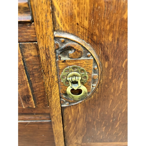 140 - An oak sideboard with three central drawers, two outer cupboard doors and baluster supports - approx... 