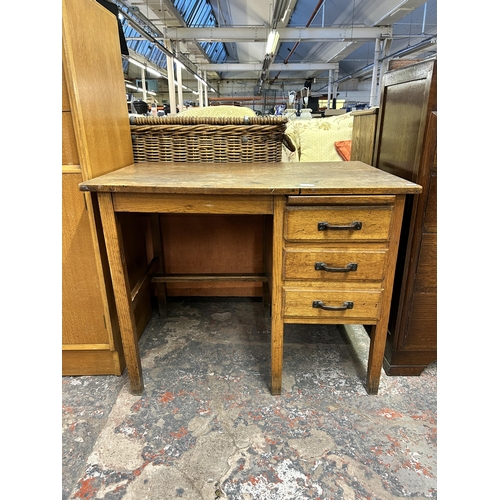 144 - A mid 20th century oak office desk with three drawers - approx. 71.5cm high x 91cm wide x 61cm deep