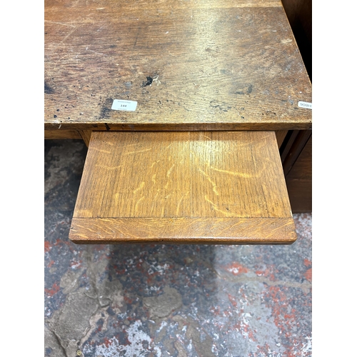 144 - A mid 20th century oak office desk with three drawers - approx. 71.5cm high x 91cm wide x 61cm deep