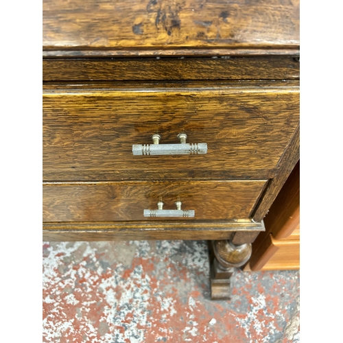 147 - An oak bureau with carved fall front, two drawers and baluster supports - approx. 101cm high x 72cm ... 