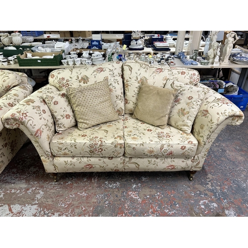 160 - A Regency style floral upholstered two seater sofa with mahogany supports and brass castors - approx... 