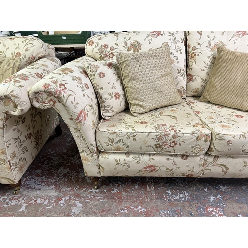 160 - A Regency style floral upholstered two seater sofa with mahogany supports and brass castors - approx... 