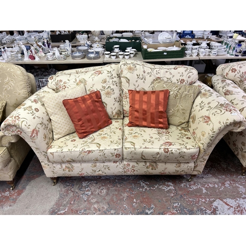 160A - A Regency style floral upholstered two seater sofa with mahogany supports and brass castors - approx... 