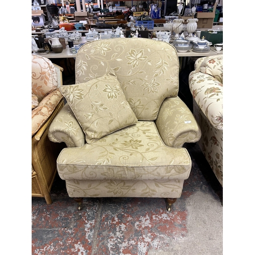 161 - A Regency style floral upholstered armchair with mahogany supports and brass castors - approx. 100cm... 