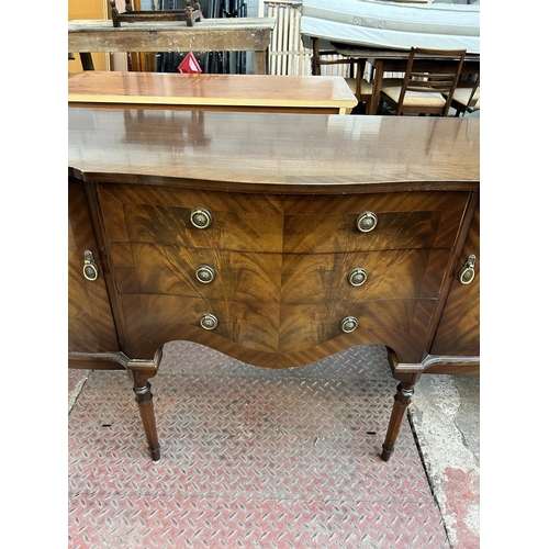 33 - A George IV style mahogany serpentine sideboard with three central drawers, two outer cupboard doors... 