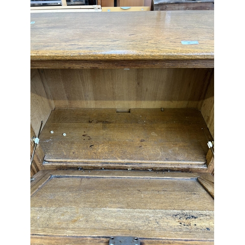 36 - A late 20th century oak cabinet with fall front and two lower cupboard doors - approx. 121cm high x ... 