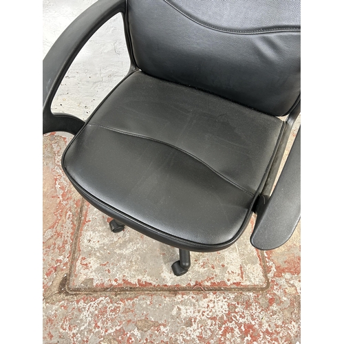 52 - A modern black leatherette and plastic swivel office desk chair