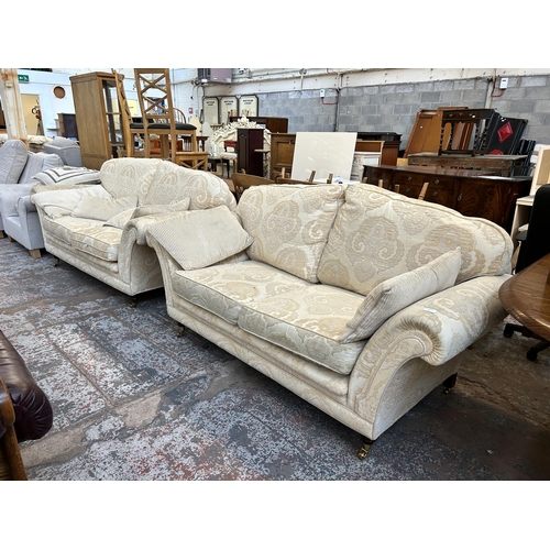 57 - A Regency style floral upholstered two piece lounge suite with mahogany supports and brass castors