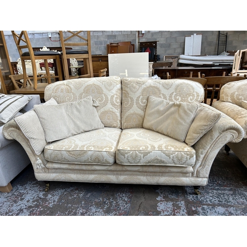 57 - A Regency style floral upholstered two piece lounge suite with mahogany supports and brass castors