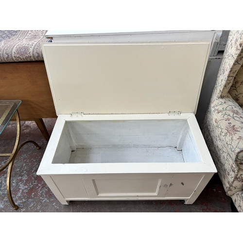 64 - A mid 20th century white painted blanket box with castors - approx. 48cm high x 89cm wide x 44cm dee... 