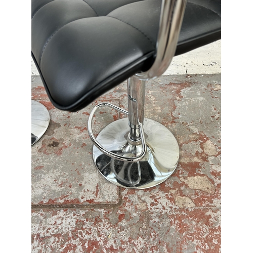 65 - A pair of modern black leatherette and chrome plated kitchen bar stools