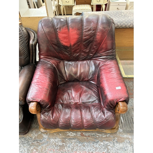 67 - An oxblood leather and carved oak armchair