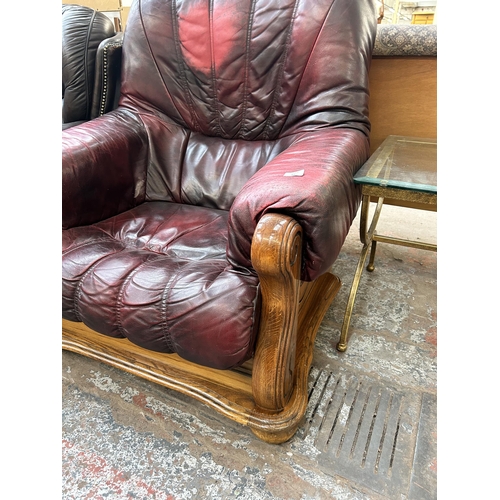 67 - An oxblood leather and carved oak armchair