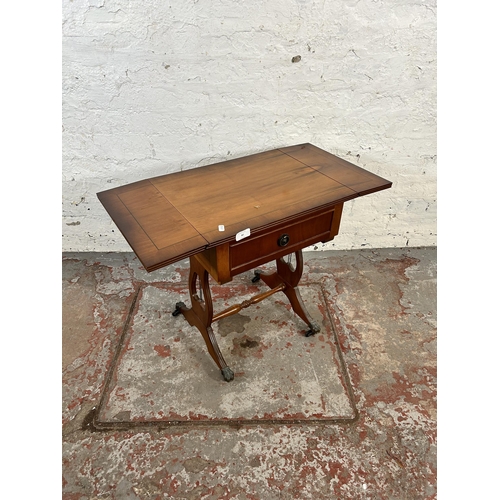 80 - A Regency style yew wood effect drop leaf lyre end side table with single drawer and brass lion paw ... 