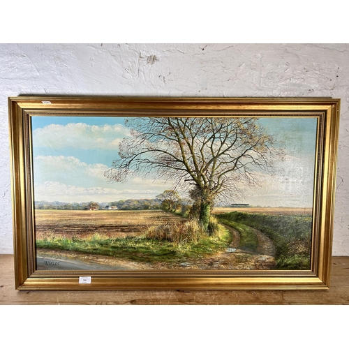 164 - A 20th century gilt framed Monica Childs oil on canvas of a landscape scene signed lower left - appr... 