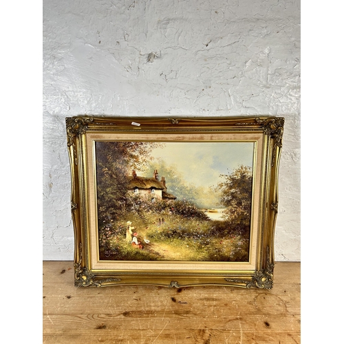 174 - A gilt framed oil on canvas of a cottage scene signed lower left 'Les Parson' - approx. 54cm high x ... 