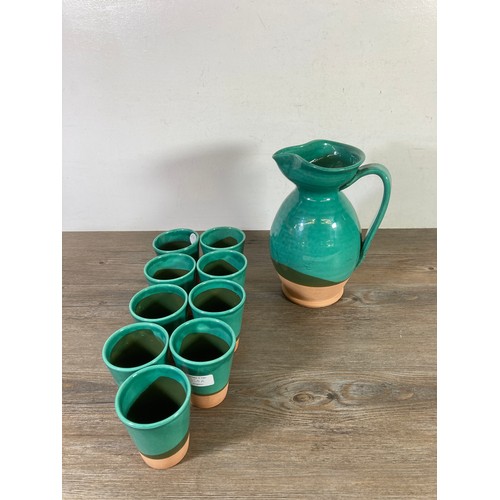 300 - A Past Times Medieval glazed terracotta ten piece drinking set comprising nine beakers and one pitch... 