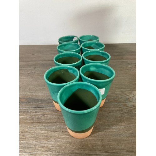 300 - A Past Times Medieval glazed terracotta ten piece drinking set comprising nine beakers and one pitch... 