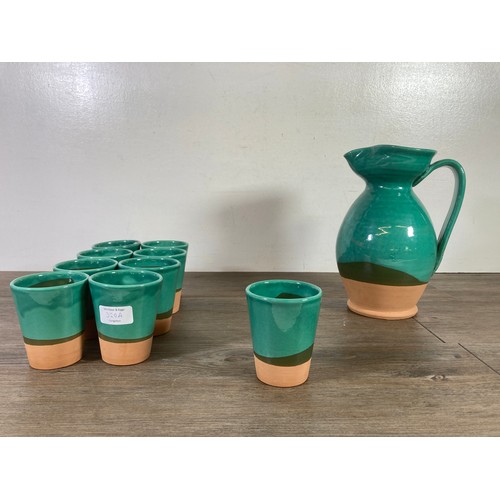 300 - A Past Times Medieval glazed terracotta ten piece drinking set comprising nine beakers and one pitch... 