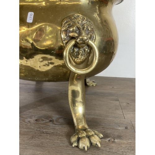 307 - A Victorian brass cauldron with lion paw supports and lion head design handles - approx. 37cm high x... 