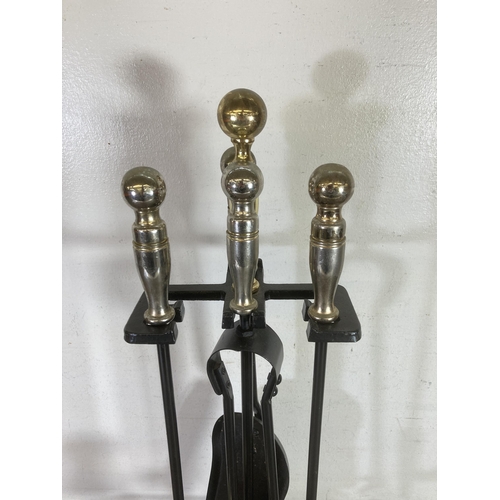 310 - A cast metal and brass effect fireside companion set - approx. 60cms high