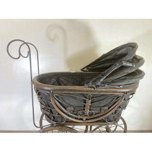 334 - A vintage cast metal and wicker dolls pram