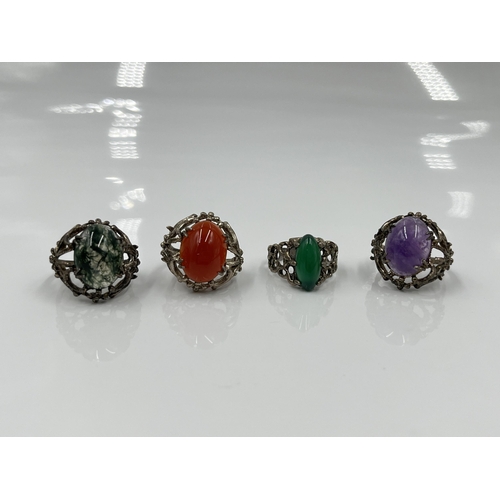 1134 - Four stamped silver gemstone solitaire rings to include moss agate, carnelian etc.