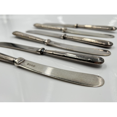 1250 - A cased set of six George V EPNS butter knives with hallmarked Sheffield silver handles, dated 1927 ... 