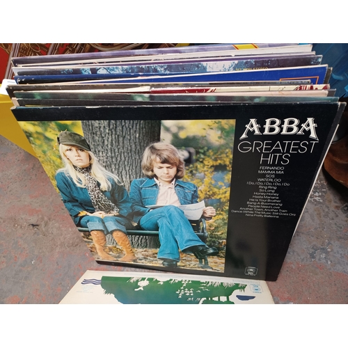 765 - A plastic yellow box containing LP vinyl records to include Abba, Tom O'Connor, Klaus Wunderlich etc... 