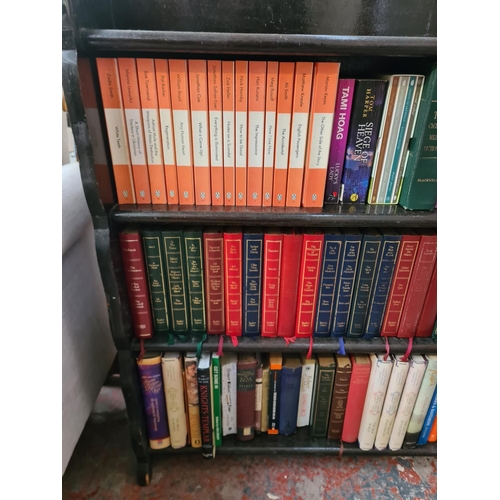 45F - A mid 20th century oak four tier bookcase containing books - approx. 93cm high x 91cm wide x 19cm de... 