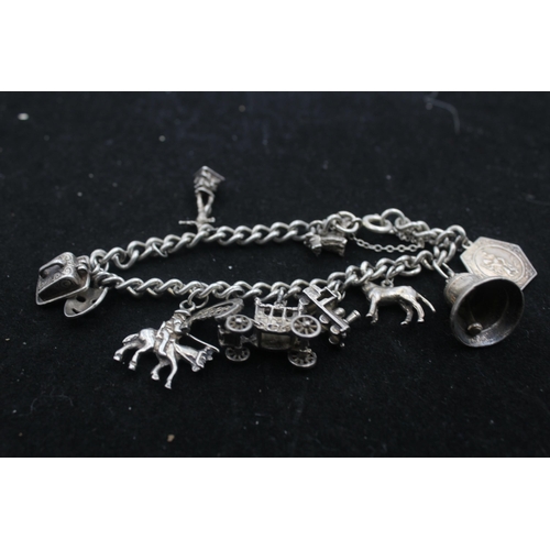 1154B - A .925 silver charm bracelet with assorted charms - approx. gross weight 45 grams