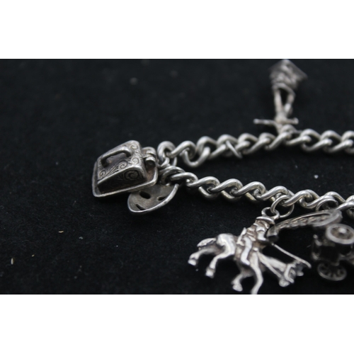 1154B - A .925 silver charm bracelet with assorted charms - approx. gross weight 45 grams