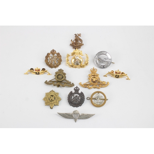 1253 - Twelve military cap badges to include Submariner, R.A Spinning Wheel etc.