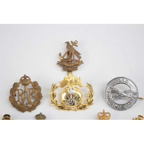 1253 - Twelve military cap badges to include Submariner, R.A Spinning Wheel etc.