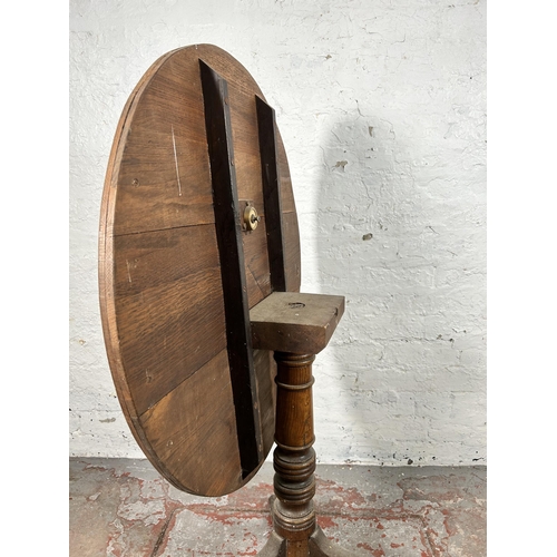 5 - A 19th century oak circular tilt top occasional table - approx. 117cm high x 78cm diameter