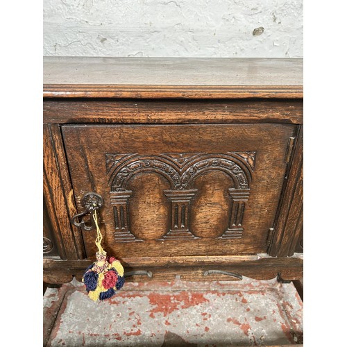 22 - A 17th century style carved oak single door cabinet - approx. 74cm high x 94cm wide x 35cm deep