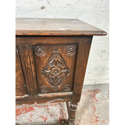 22 - A 17th century style carved oak single door cabinet - approx. 74cm high x 94cm wide x 35cm deep