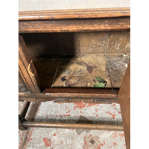 22 - A 17th century style carved oak single door cabinet - approx. 74cm high x 94cm wide x 35cm deep