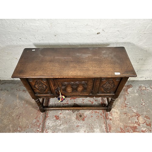 22 - A 17th century style carved oak single door cabinet - approx. 74cm high x 94cm wide x 35cm deep