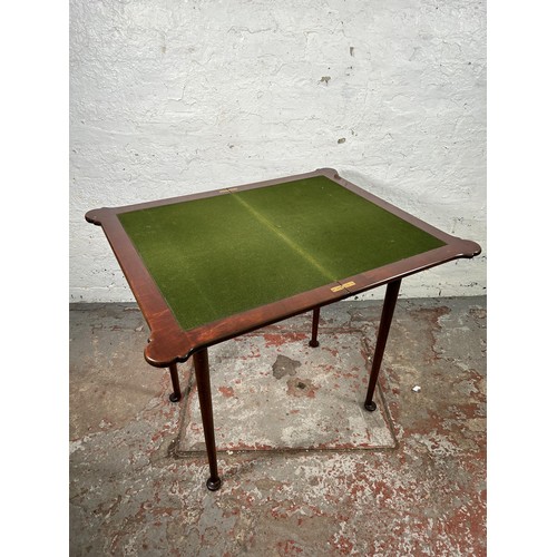 39 - An Edwardian mahogany folding games table with green baize interior and padded feet - approx. 72cm h... 