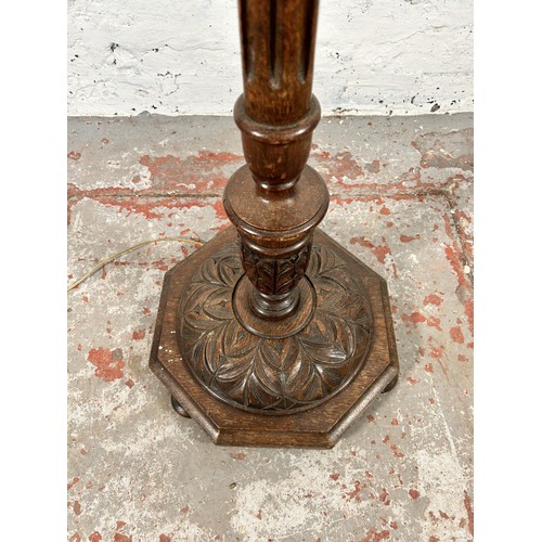 48 - A carved oak standard lamp - approx. 135cm high