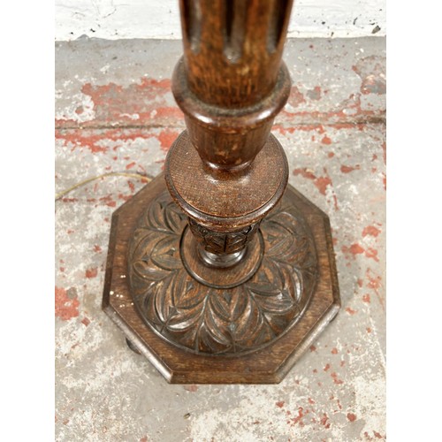 48 - A carved oak standard lamp - approx. 135cm high