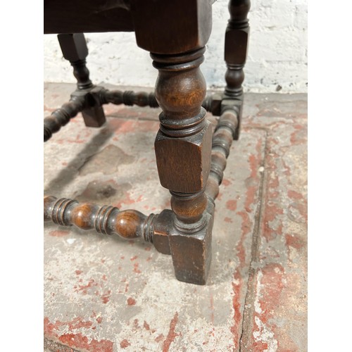 50 - A 17th century style oak circular side table with turned stretchers - approx. 39cm high x 69cm diame... 