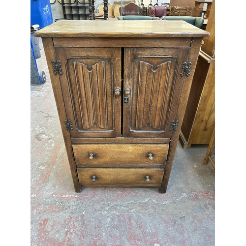 105 - A Goodalls of Manchester oak linenfold cabinet with two doors and two drawers  - approx. 116cm high ... 